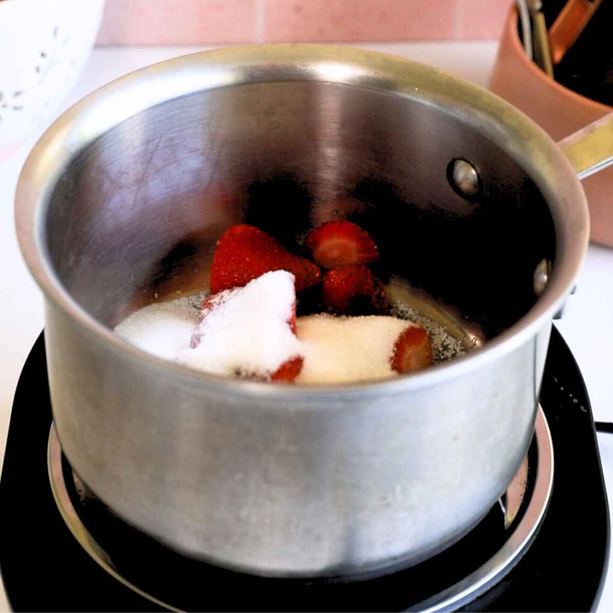 strawberries, sugar, and water, in a medium sized metal pan.
