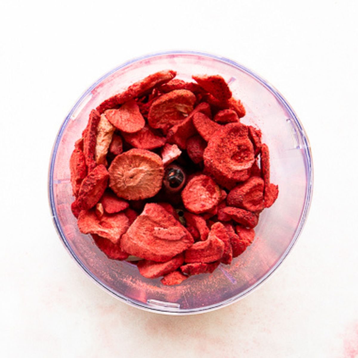 unblended freeze dried strawberries in the bowl of a food processor.
