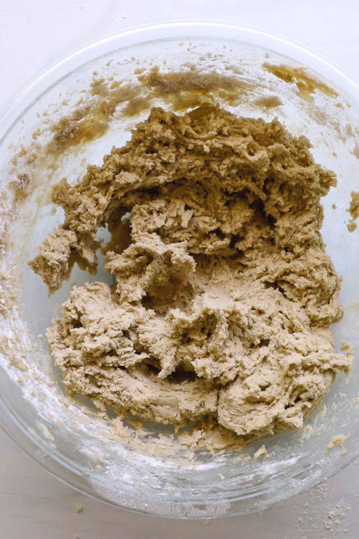 cookie dough with flour mixed in, in glass bowl.