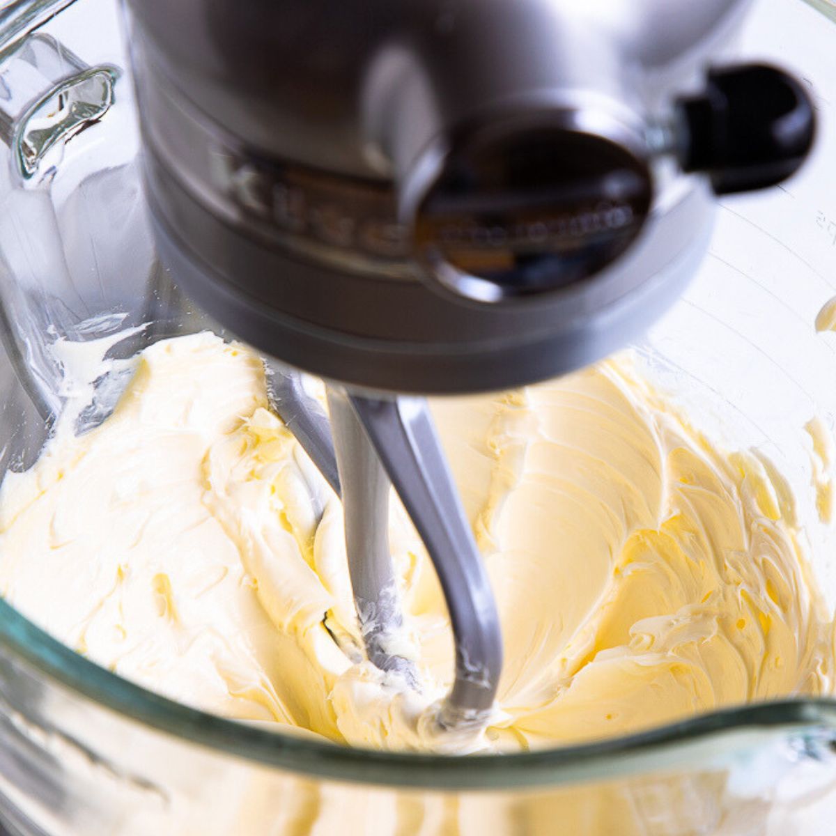 creamed butter inside of a grey standing mixer.