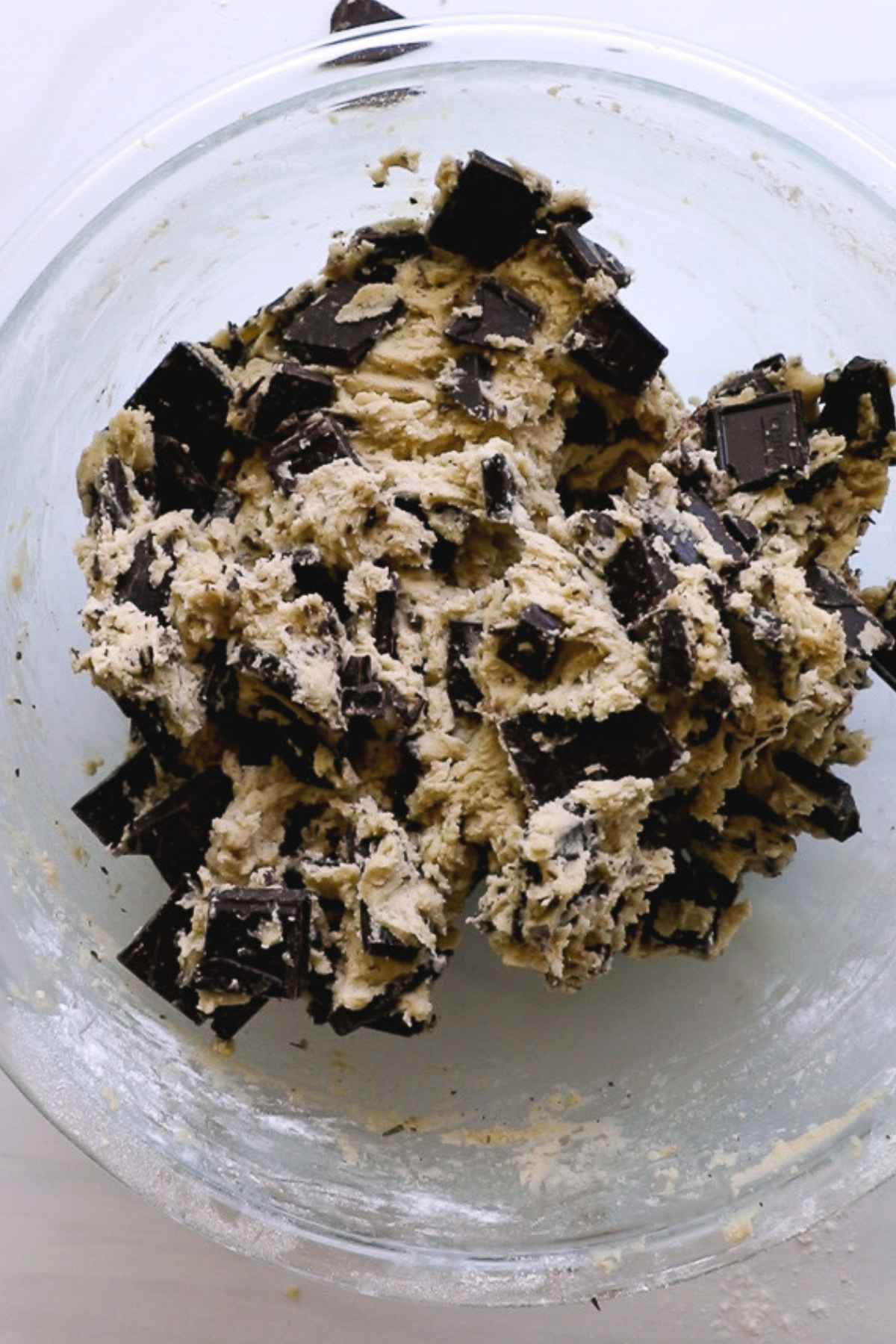 cookie dough with chocolate mixed in glass bowl.