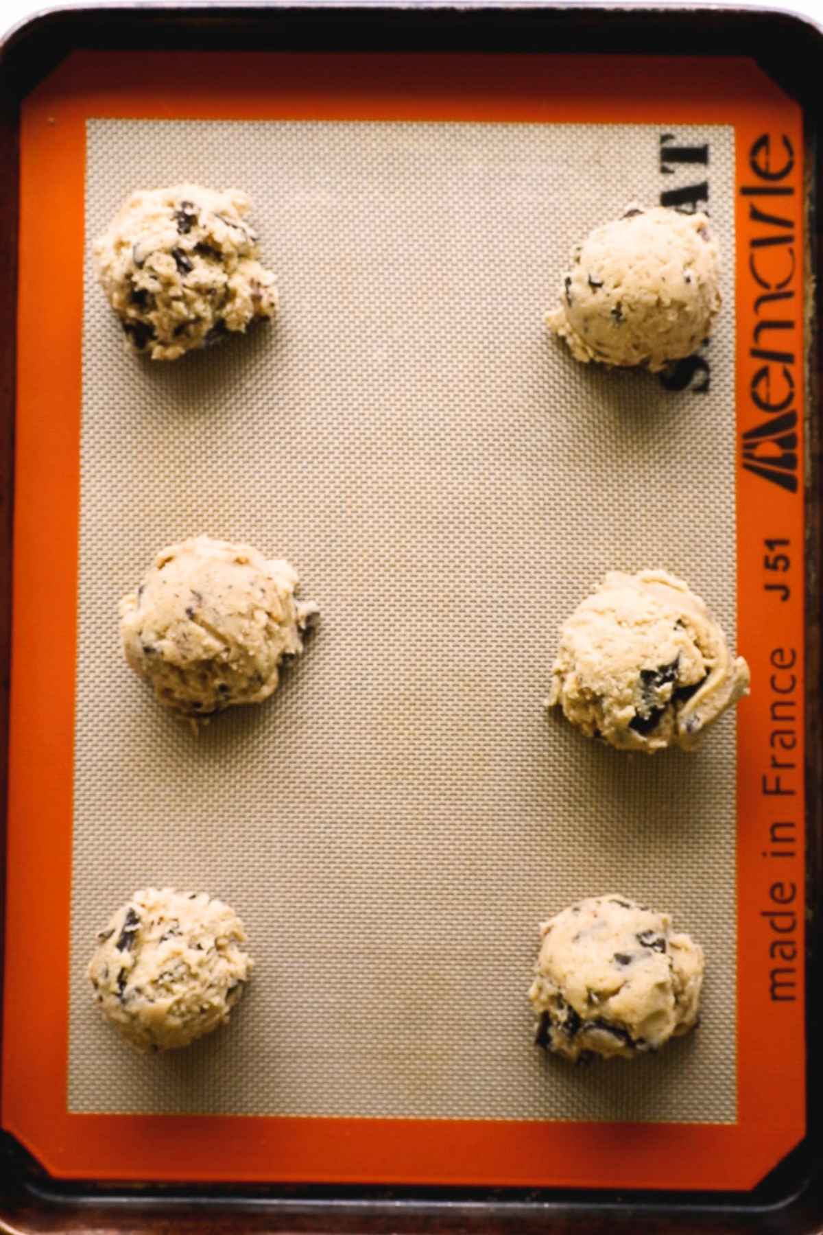 chilled cookie dough balls on baking sheet ready to bake,
